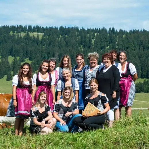 une photo de groupe avec des dames souriantes en tenues traditionnelles